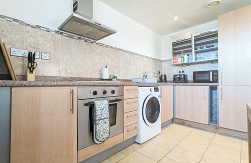 Chinatown Apartment | Stylish 2-bed flat sleeps 6. Double ensuite + bunk room, open-plan kitchen/lounge with sofa bed & TV. Private parking. 15min walk to Etihad Stadium, 6min drive to Piccadilly Station. Perfect for groups!