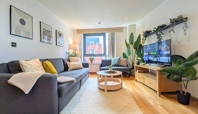 Stylish 2-bed flat sleeps 6. Double ensuite + bunk room, open-plan kitchen/lounge with sofa bed & TV. Private parking. 15min walk to Etihad Stadium, 6min drive to Piccadilly Station. Perfect for groups!